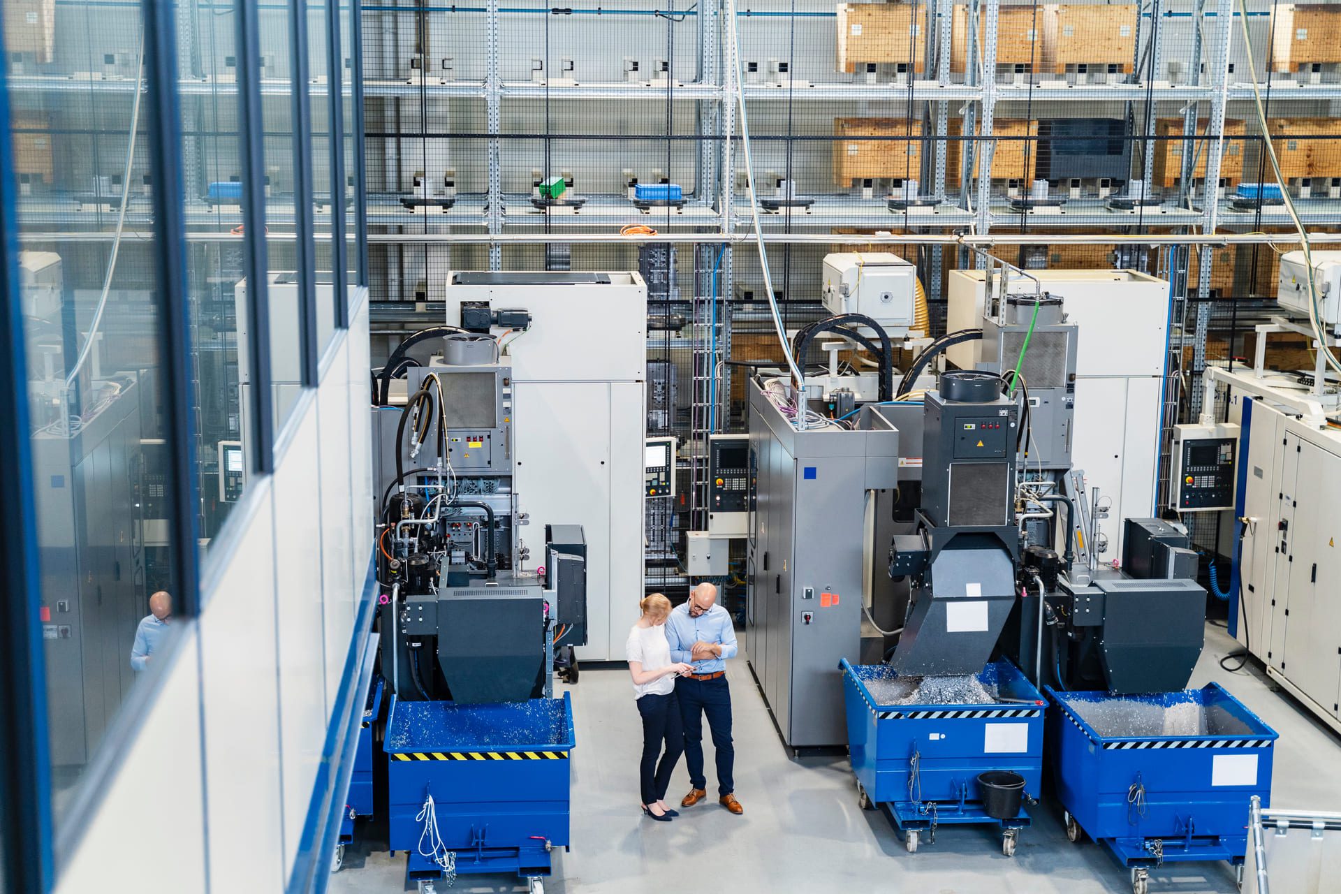Engineer in safety vest inspecting automated equipment
