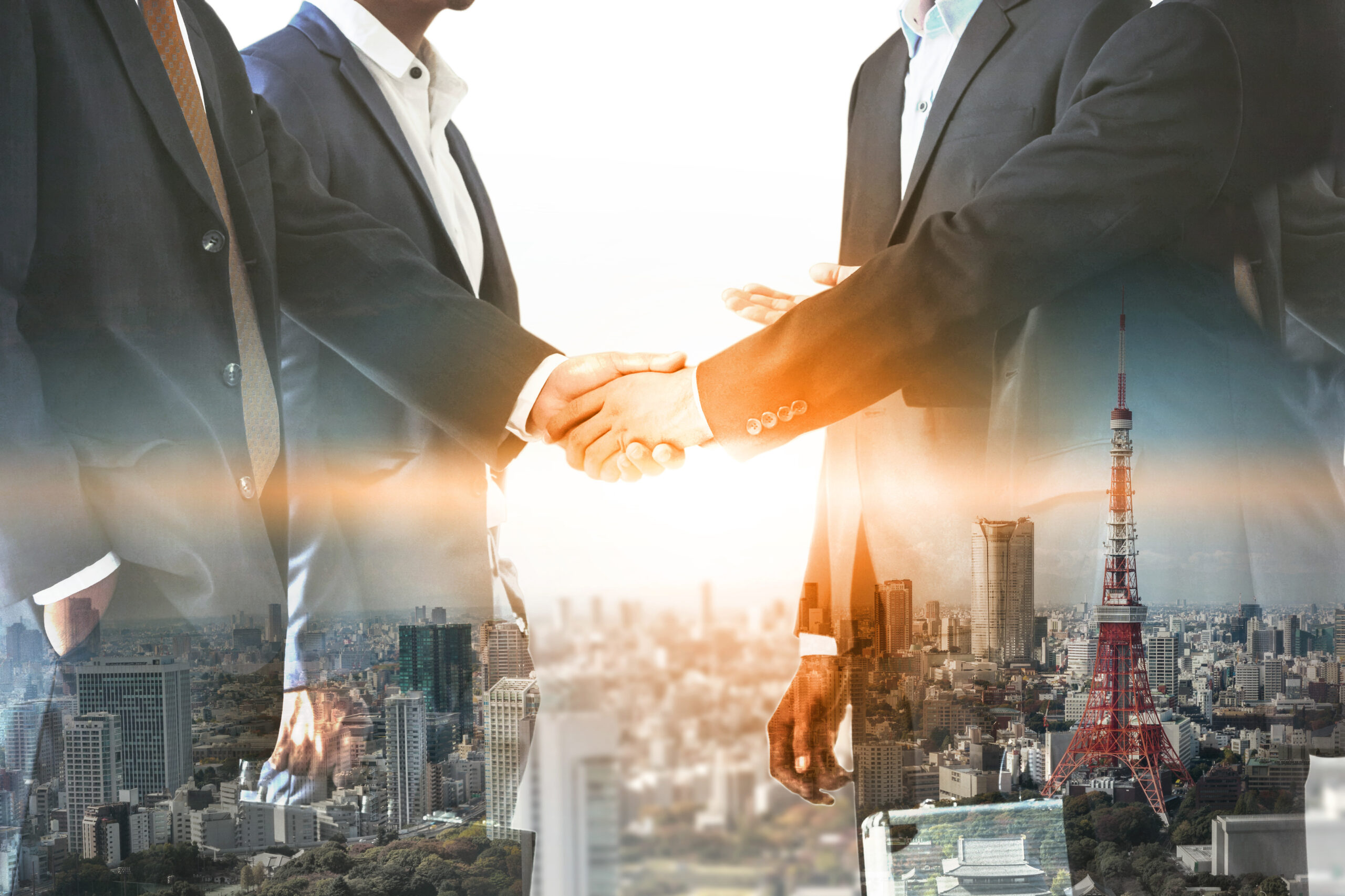 Business executives shaking hands with a city skyline in double exposure